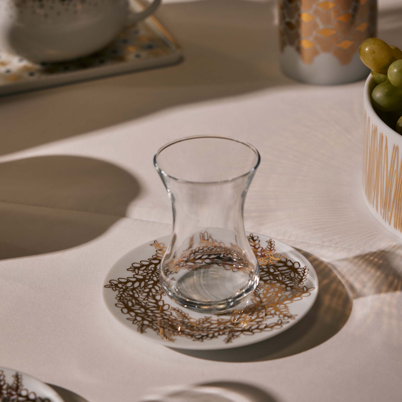 صلصال طقم تمرة بالتعاون مع رزان العزوني تارا المؤلف من فنجانين عربيين للشاي مع صحنيهما باللون الذهبي